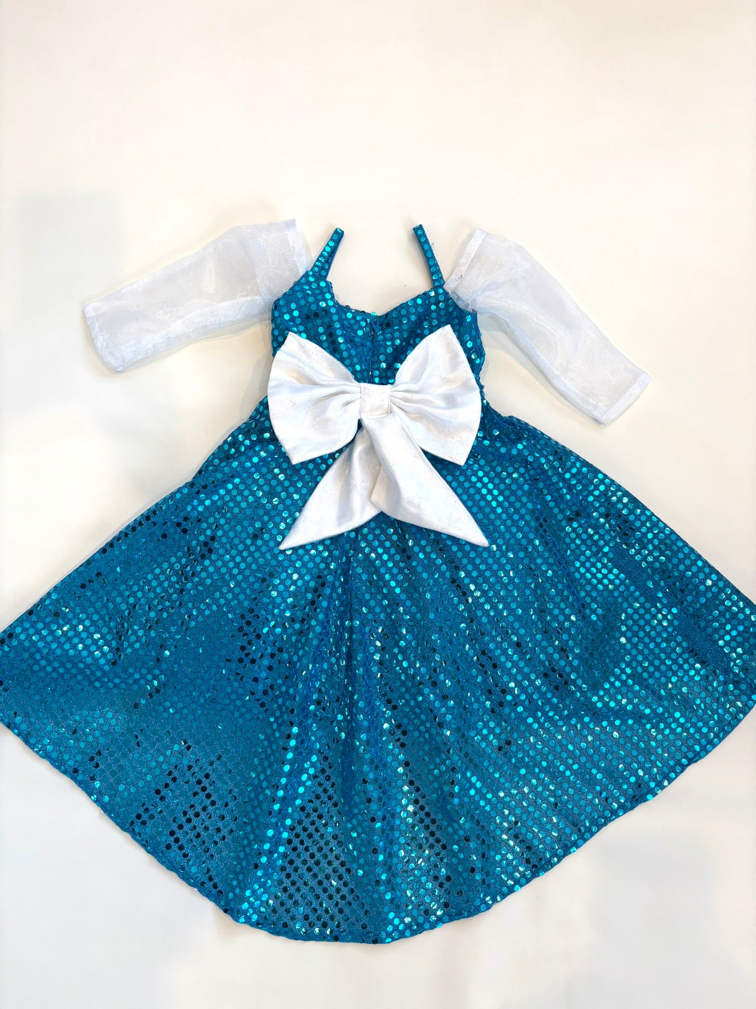 Blue sequin dress with a large white bow on a white background