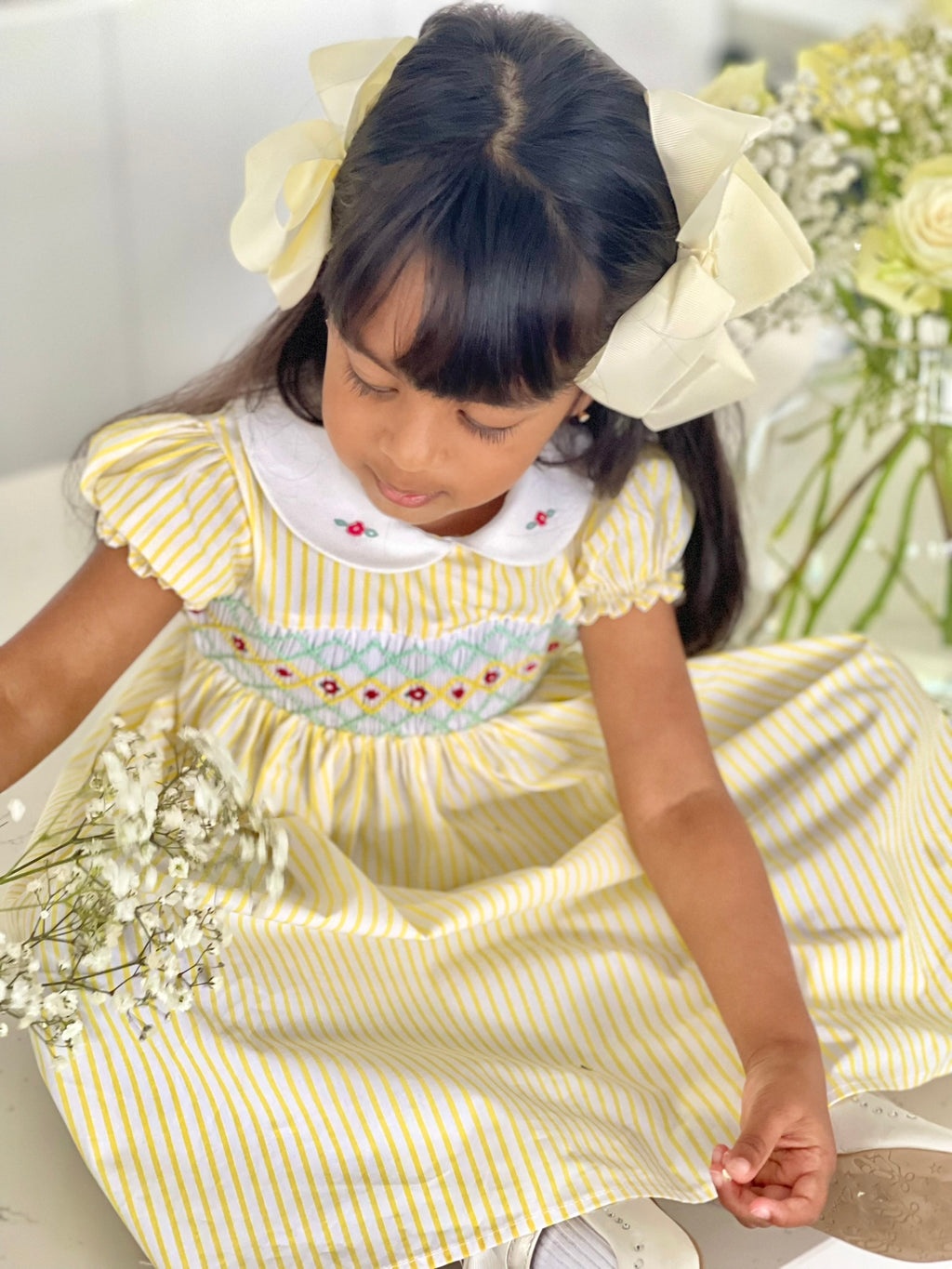 Girl sitting- full length-Girl wearing the marigold smock dress handsmocked yellow and white stripe dress 3- close up