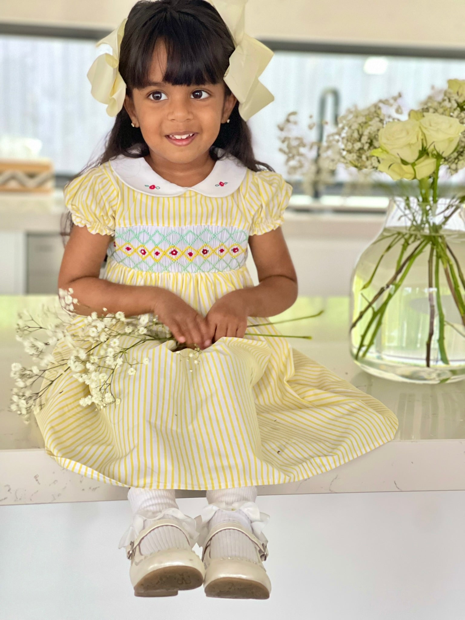 Girl sitting- full length-Girl wearing the marigold smock dress handsmocked yellow and white stripe dress 2