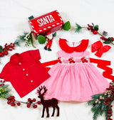 Red collar with frills, pink and white gingham dress with red hand-smocked bunnies and roses in the middle of the dress with a contrasting red rear bow stash and matching this dress is a red cotton shirt with red satin rose on the pocket with contrasting white buttons