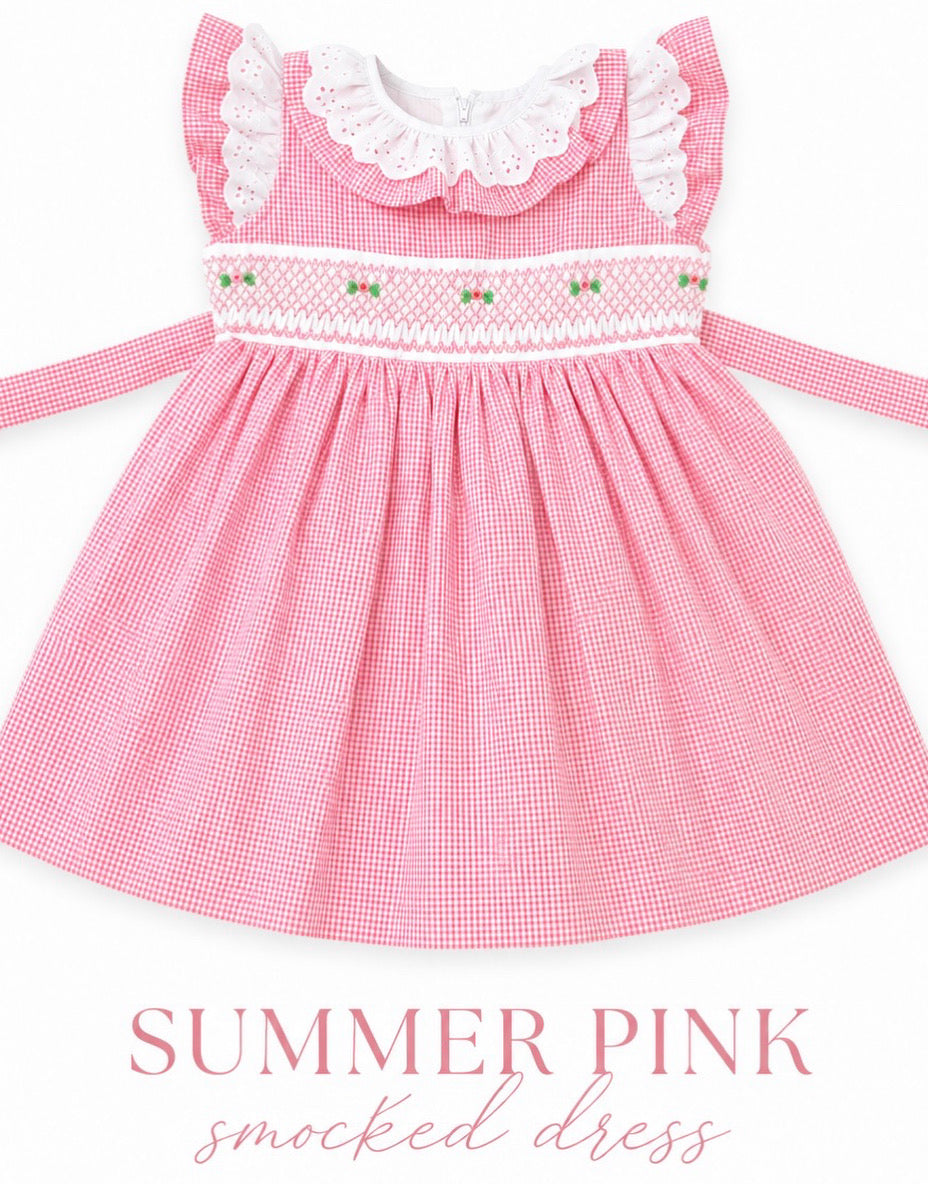 A pink and white gingham smocked dress for toddlers, featuring a white ruffled collar, a smocked bodice with small green and pink embroidered details, and matching tie straps on the sides. The text 'SUMMER PINK' and 'smocked dress' is printed below the dress on a white background.