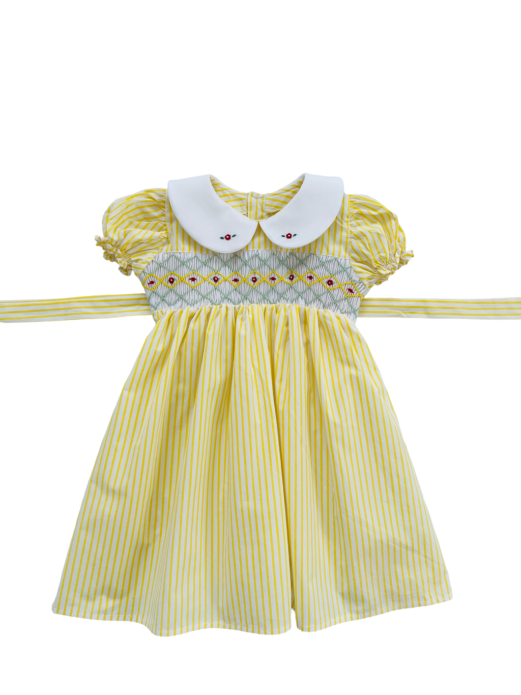  100% cotton fabric in a cheerful yellow and white stripe design. The hand-smocked bodice combines yellow, green and white smocking with red floral embroidery, creating a sunny, playful vibe.