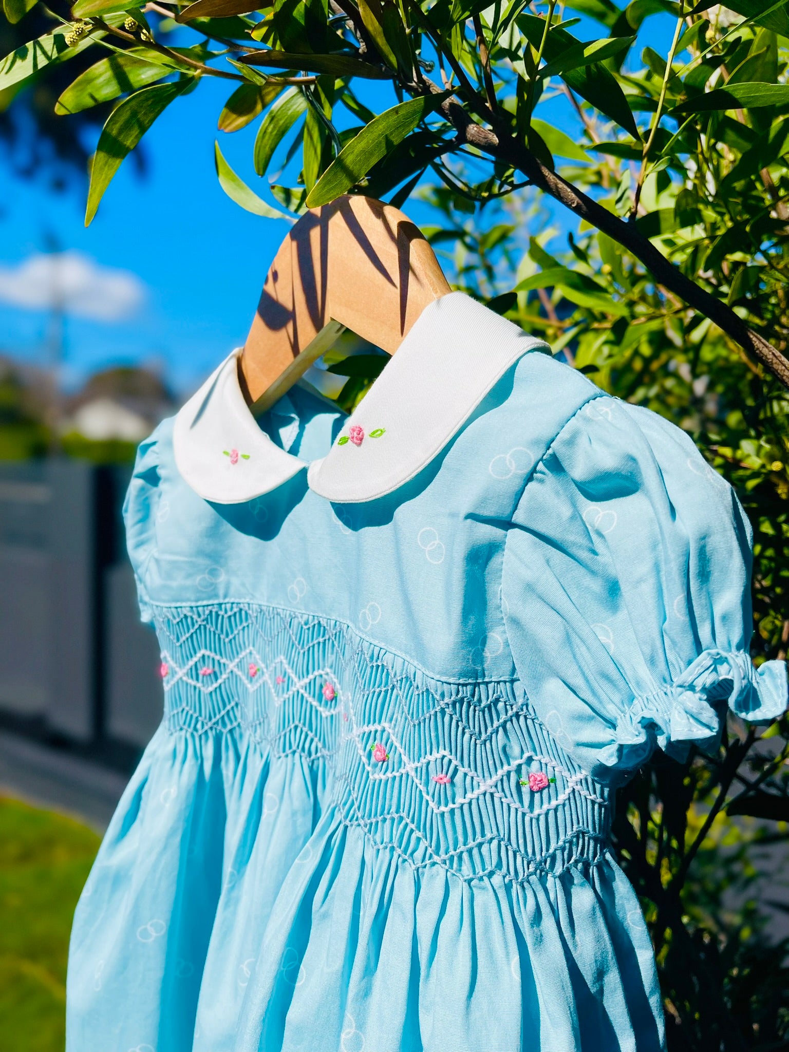 close up of the top half of the bluebell dress handsmocking, collar and sleeves in the light blue shade of colour